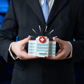 The hospital building is in the hands of a businessman. Patron. Private support for healthcare, sponsorship and social responsibility. Philanthropy, healthcare funding and public private partnership.